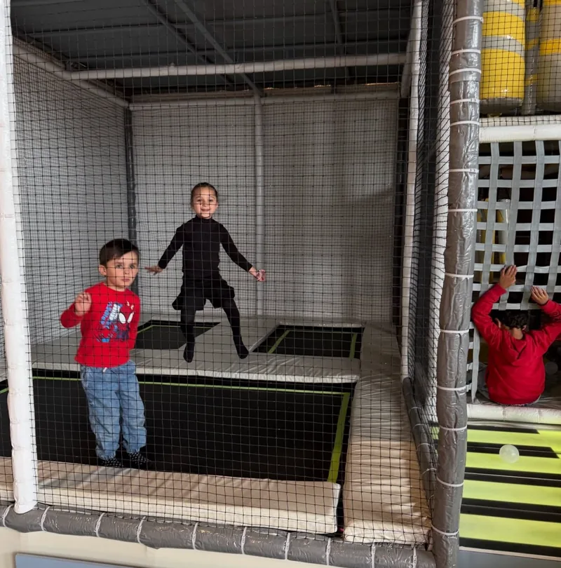Niños saltando en los trampolines del área de aventura
