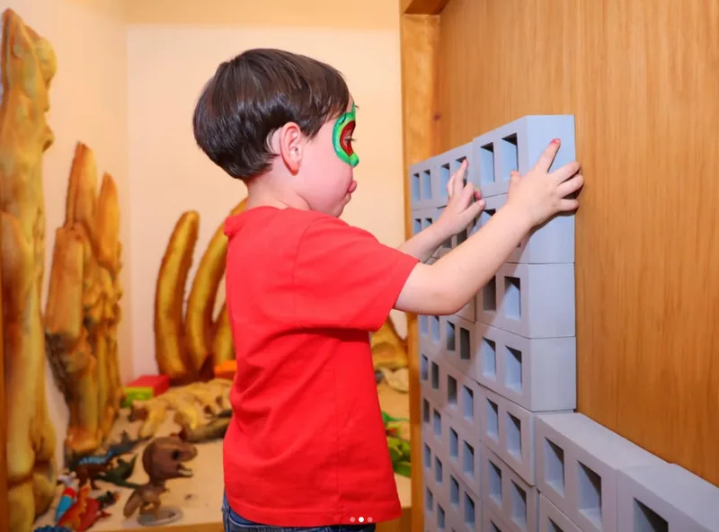 Niño armando una pared con bloques gigantes